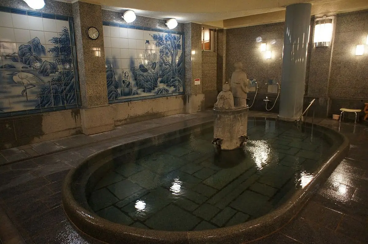Empty granite soaking tub inside the Kami no Yu bath at Dogo Onsen Honkan