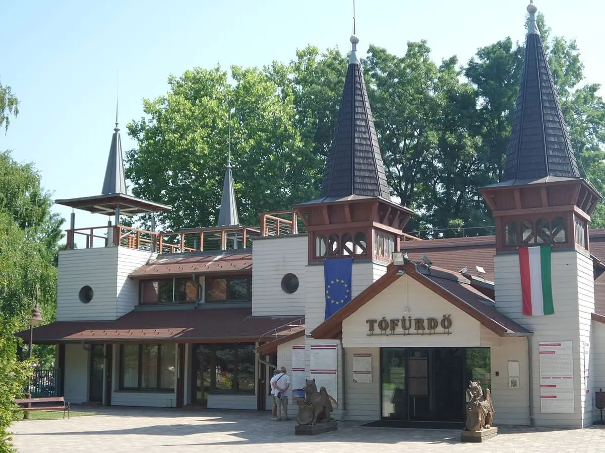 Entrance building of the Hévíz lake bath with dark spires and a Tófürdő sign