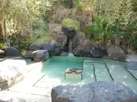 Rock edged Maya thermal pool with a small waterfall in the gardens of Parco Termale Negombo