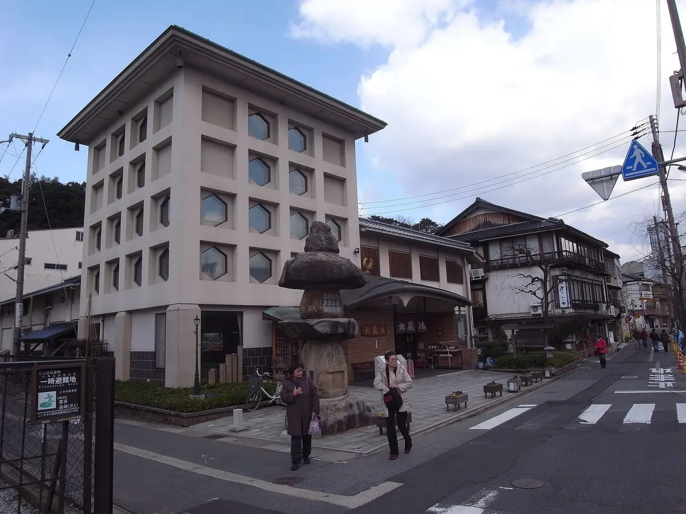 Jizoyu public bathhouse in Kinosaki Onsen with hexagonal windows and a tall stone lantern