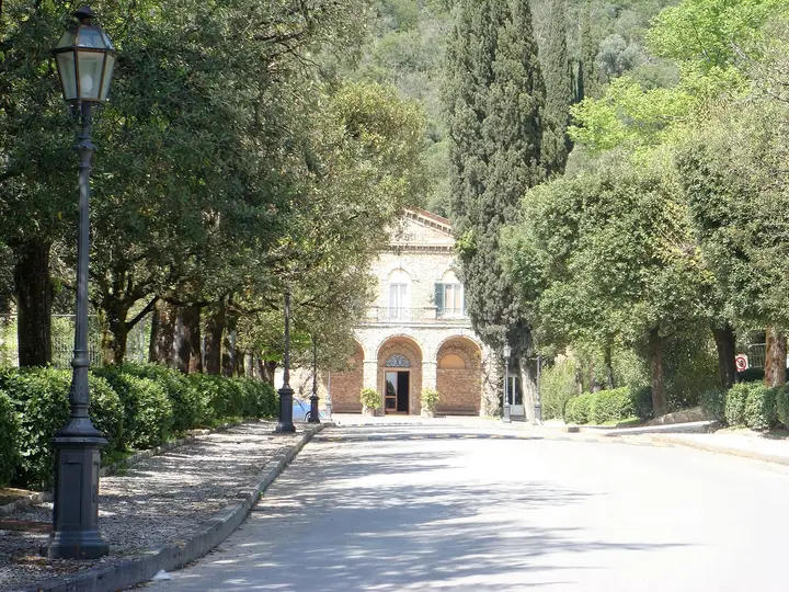 Tree lined avenue leading to the arched entrance building of Grotta Giusti in Monsummano Terme