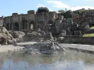 Steaming hot spring pool beside the ruined Roman bath arches at Fordongianus