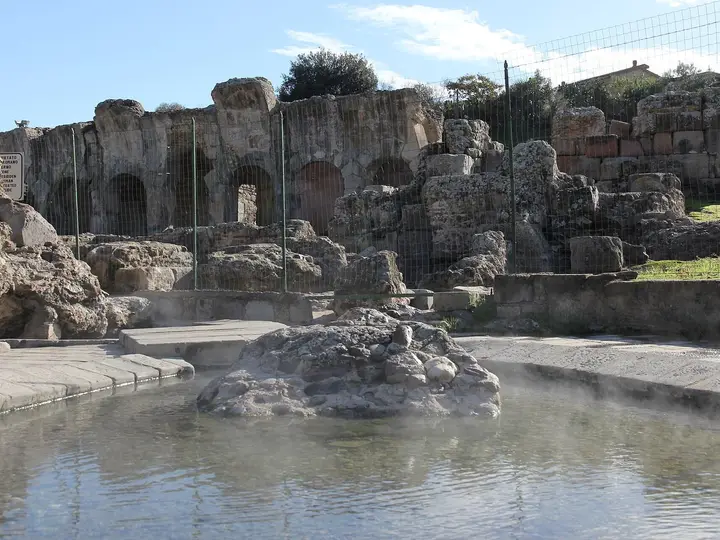 Steaming hot spring pool beside the ruined Roman bath arches at Fordongianus