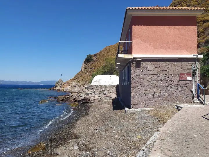 Stone buildings of the Eftalou hot baths on a pebble beach beside the sea on Lesbos