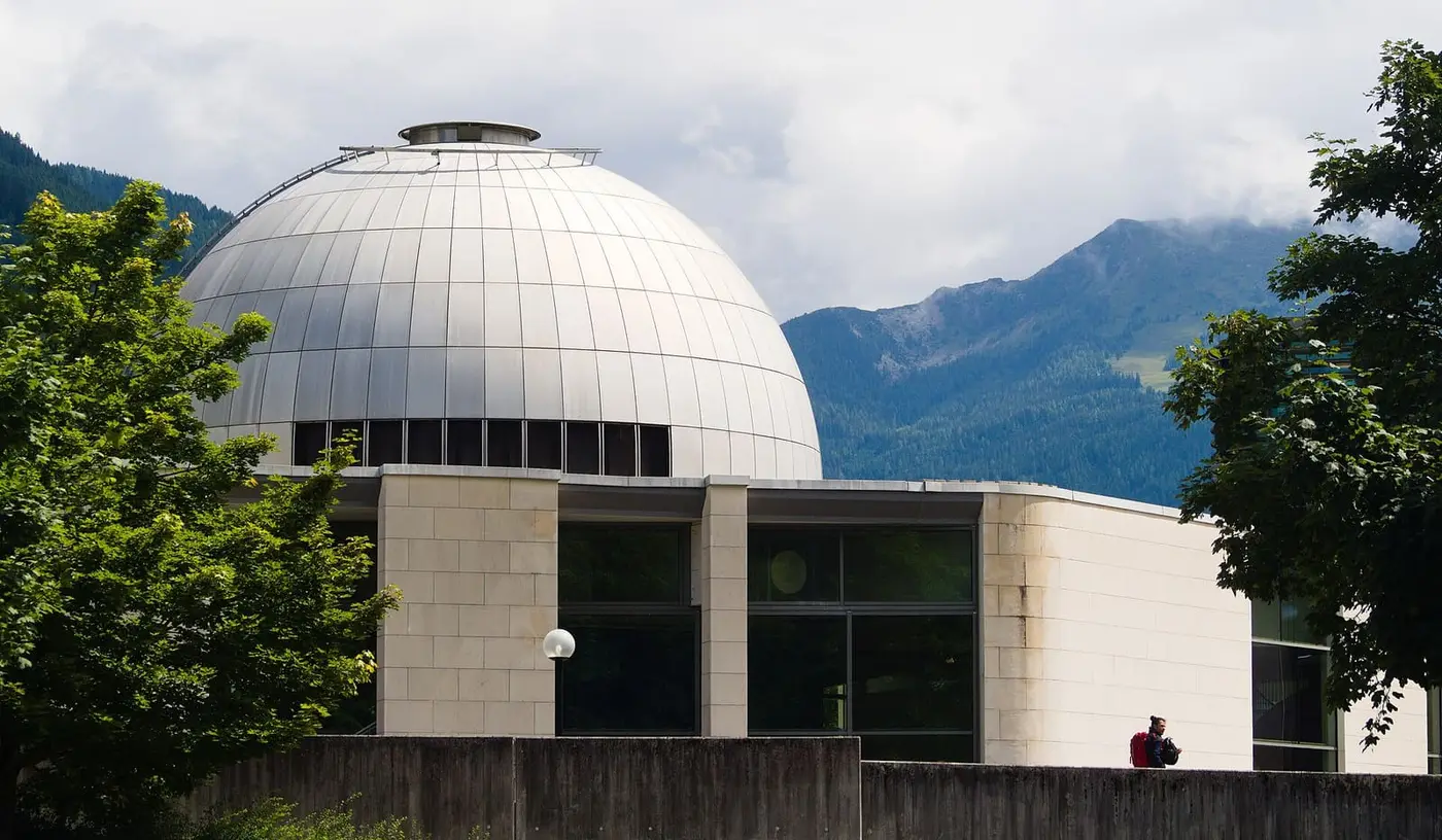 Silver dome of the Alpentherme Gastein in Bad Hofgastein with green mountains behind