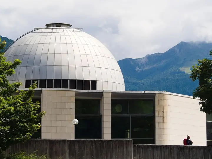 Silver dome of the Alpentherme Gastein in Bad Hofgastein with green mountains behind