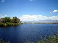 Blue water of Roper Lake near Safford with tree lined shore and distant mountains