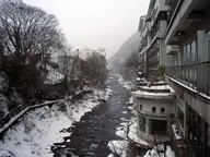 Snowy Tone River gorge lined with tall ryokan buildings at Minakami Onsen