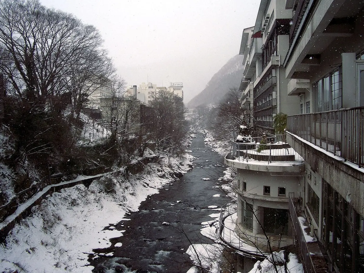 Snowy Tone River gorge lined with tall ryokan buildings at Minakami Onsen