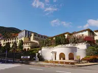Hakone Kowakien Yunessun resort buildings with a white arched entrance among autumn hills