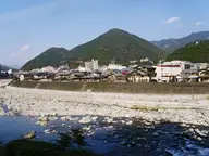 Gero Onsen hotels lining the rocky Hida River below green mountains on a clear day