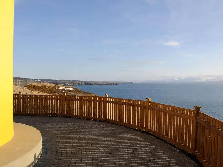 View from the yellow lighthouse on the Húsavík headland across Skjálfandi Bay to snowy mountains