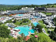 Aerial view of Thermenresort Loipersdorf with turquoise outdoor pools, water slides and green hills