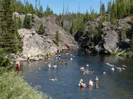 Firehole Swim Area in a rocky rhyolite canyon of the Firehole River lined with pines