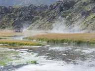 Steam rising over the warm stream at the edge of the Laugahraun lava field in Landmannalaugar