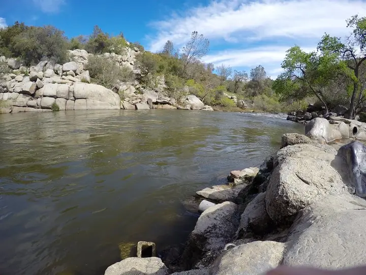 Kern River flowing past granite boulders beside Remington Hot Springs on a sunny day