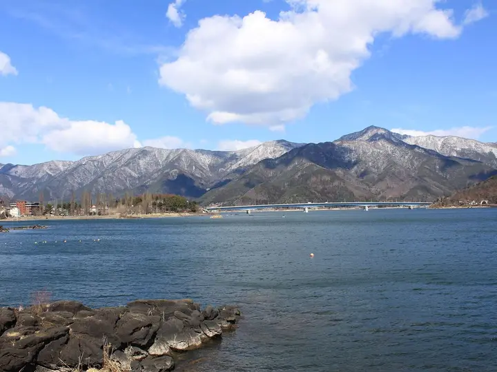 Lake Kawaguchi under blue sky with snowy mountains, the lakeside setting of Kawaguchiko Onsen