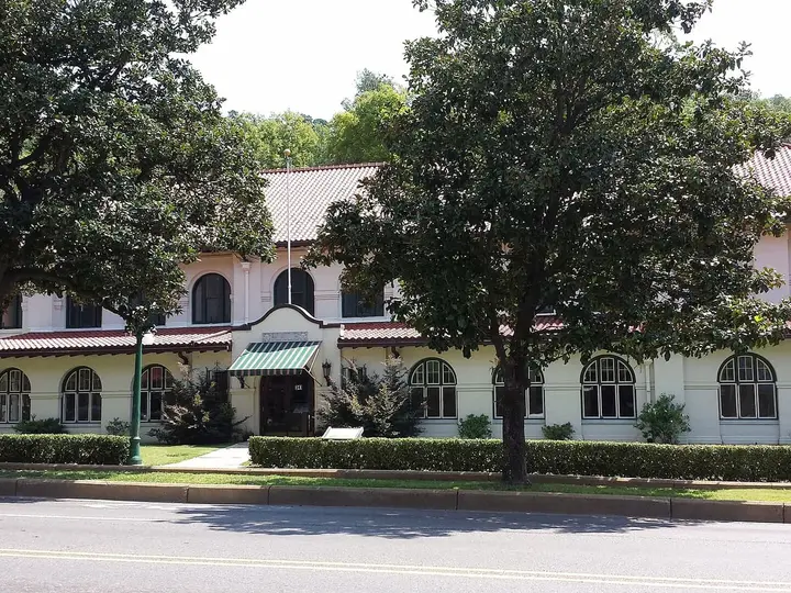 Hale Bathhouse on Bathhouse Row, a cream building with a red tile roof behind large shade trees