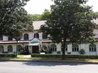 Hale Bathhouse on Bathhouse Row, a cream building with a red tile roof behind large shade trees