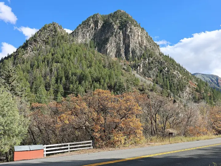 Forested rock peak and autumn oaks above Colorado Highway 133 near Avalanche Road and the ranch
