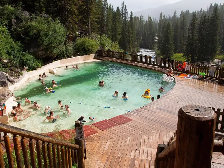 Granite Hot Springs concrete pool with wooden deck surrounded by dense evergreen forest