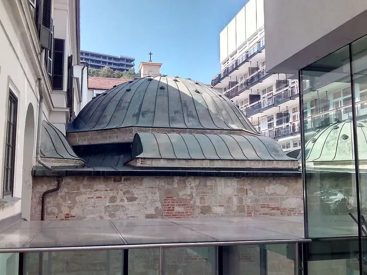 Ottoman dome of the Veli Bej Bath beside its modern glass wing in Buda