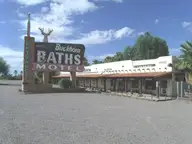 Buckhorn Baths Motel sign with deer head topper in front of the low stucco motel building in Mesa