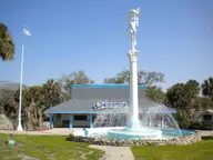 Weeki Wachee Springs attraction building with a mermaid statue fountain under a clear blue sky