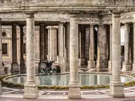 Colonnade around a round fountain pool inside the Terme Tettuccio at Montecatini
