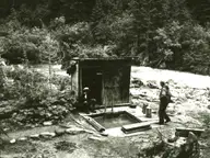 Kennedy Hot Springs in 1963, a wooden soaking pool and plank bathhouse by the White Chuck River, buried in 2003