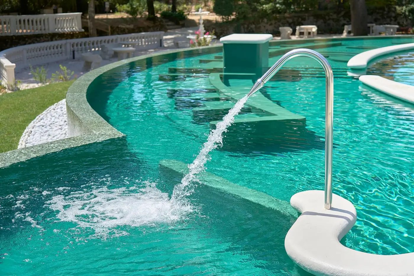 Thermal water jet splashing into a turquoise outdoor pool at Terme di Castrocaro