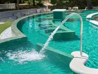 Thermal water jet splashing into a turquoise outdoor pool at Terme di Castrocaro