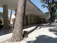 Long shaded colonnade among pine trees in the Acqua Santa spa park, Chianciano Terme