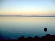 Calm Lake Laugarvatn at dusk with distant mountains on the horizon near Fontana