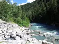 Rock-lined pools of Lussier Hot Springs beside the Lussier River in a forested valley