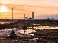 Grótta lighthouse at sunset across the tidal flats of the Seltjarnarnes shore near Kvika