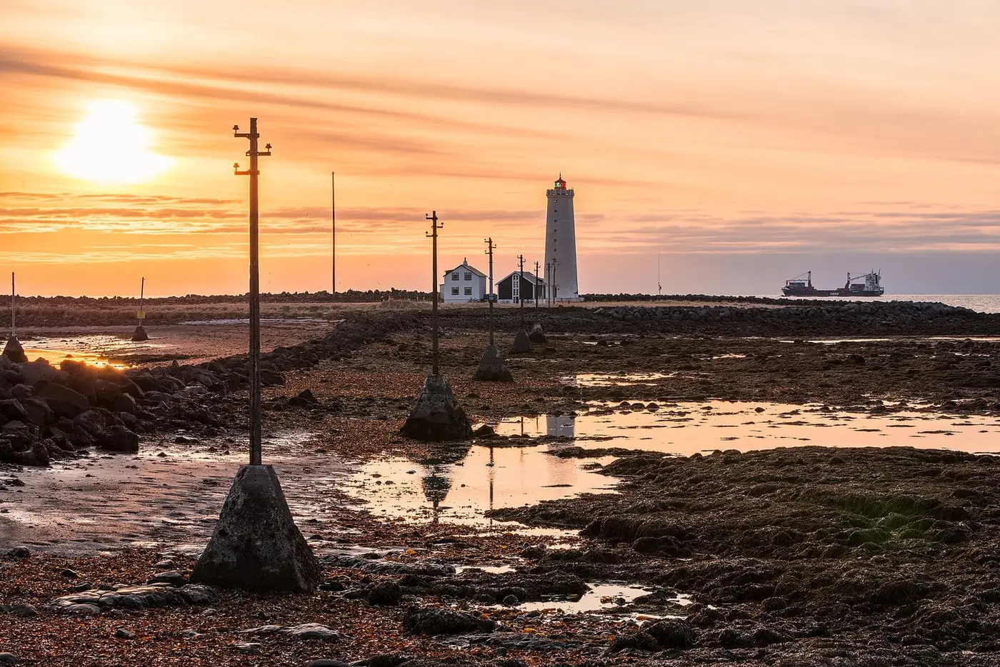 Grótta lighthouse at sunset across the tidal flats of the Seltjarnarnes shore near Kvika