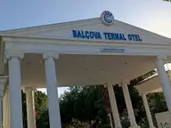 White columned entrance gate of the Balçova Termal Otel under a clear blue sky