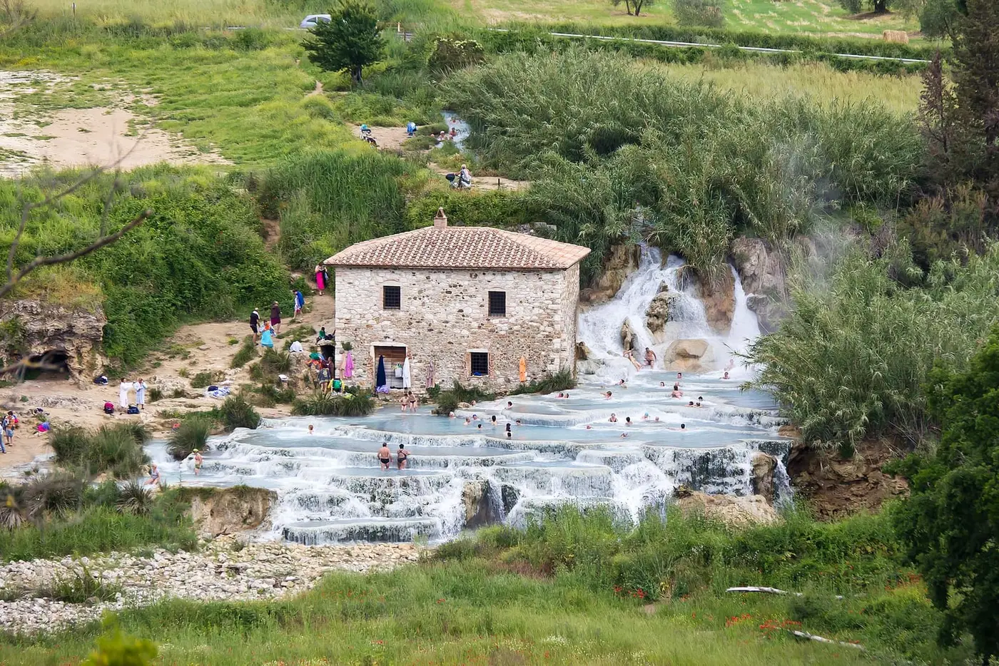 Old stone mill above the white travertine cascades and terraced pools of Cascate del Mulino
