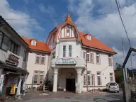 Turreted orange roofed Siebold no Yu public bathhouse in Ureshino Onsen under blue sky