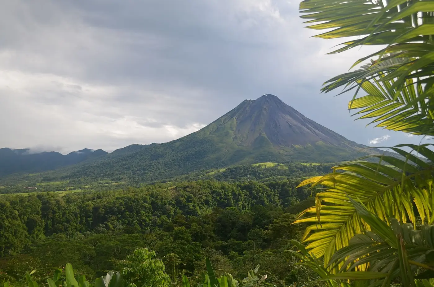 Arenal Volcano rising over rainforest, seen from The Springs Resort and Spa