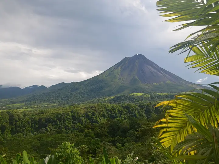 Arenal Volcano rising over rainforest, seen from The Springs Resort and Spa