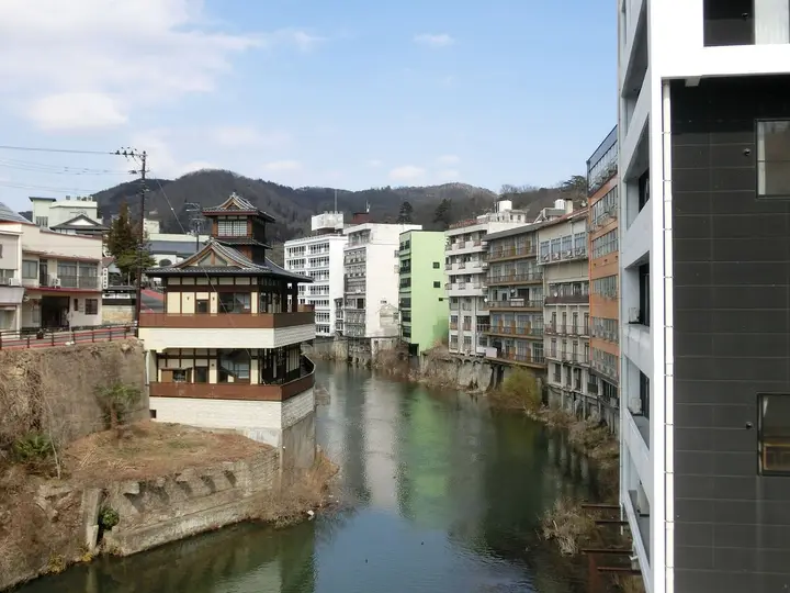 Surikami River flowing through Iizaka Onsen between hotels and a pagoda style inn