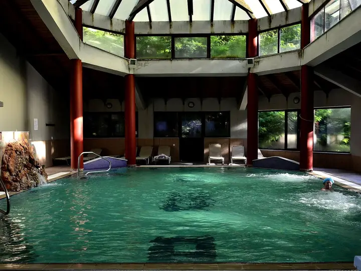 Indoor thermal pool at Loutra Smokovou under a glass roof with red columns