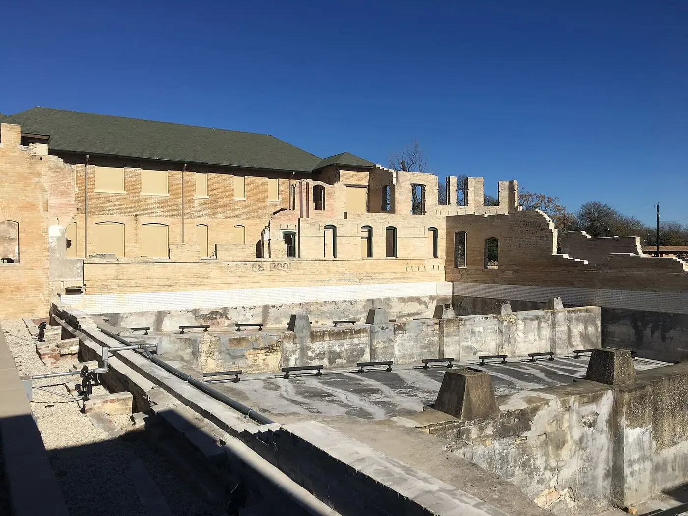 Ruined brick walls and empty concrete bathing pools of the historic Hot Wells Hotel in San Antonio