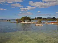 Clear shallows and small rocky islets of Lake Rotorua along the lakefront near Wai Ariki