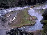 Steaming hot stream of Boiling River running beside the Gardner River along a fenced gravel path